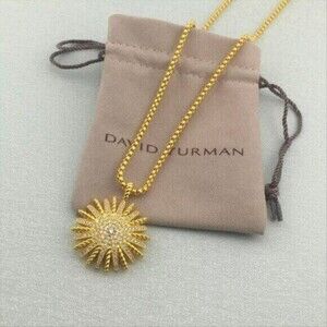 An 18K gold & diamond starburst pendant on 18 inch yellow gold chain